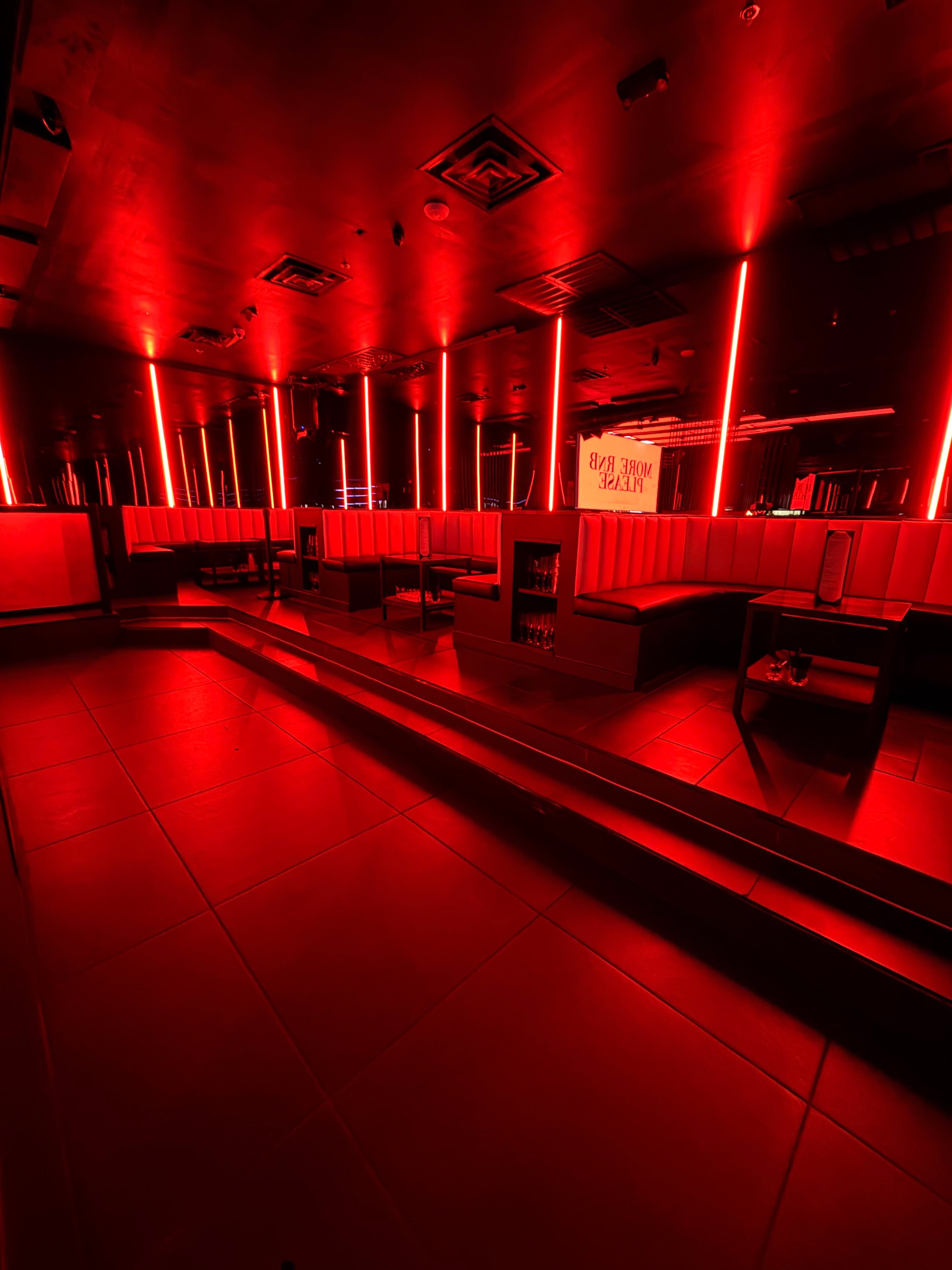 Red-lit lounge seating at Status