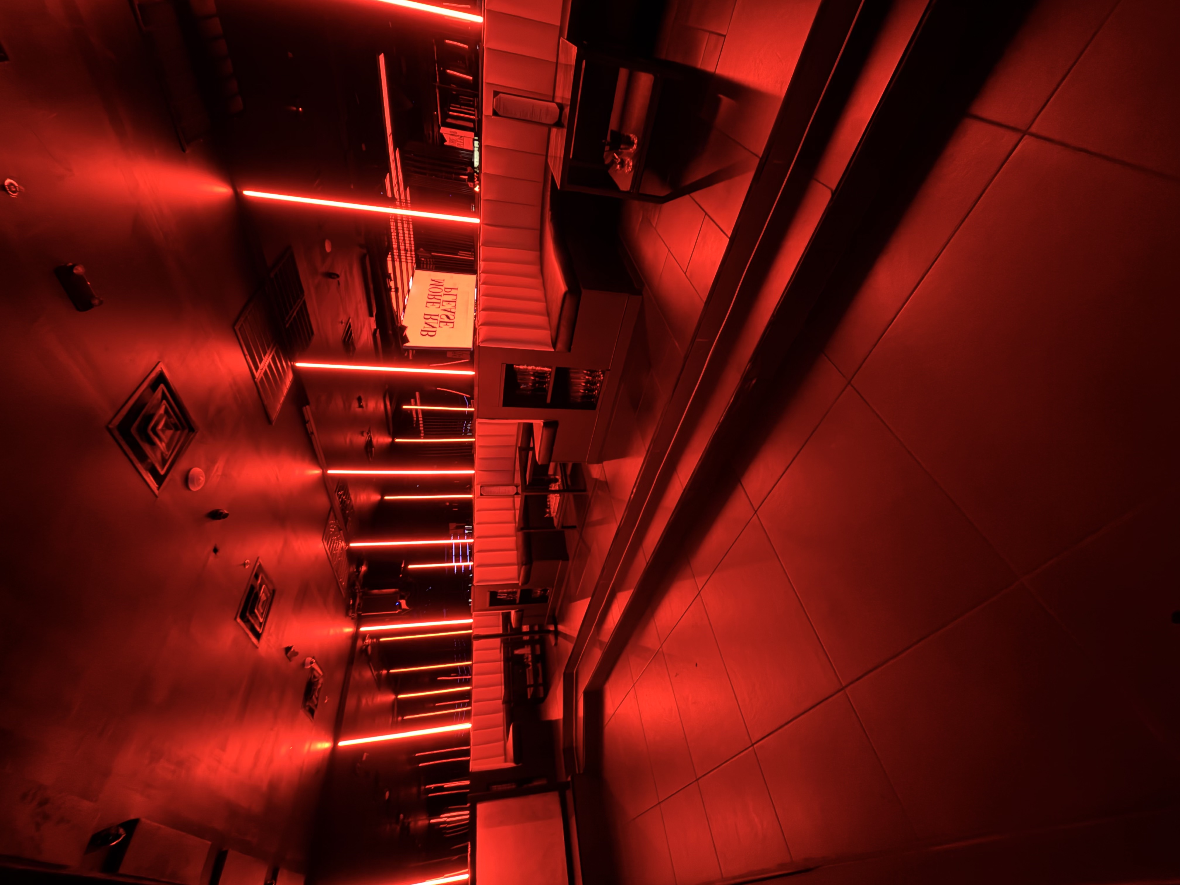 Red-lit lounge seating inside Status Club Houston